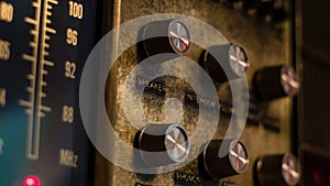 An antique wall radio unit with tuning dials and knobs