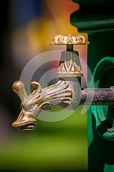 An antique water faucet in the city park