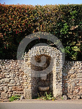 An antique water fountain not in use in a small neighbourhood