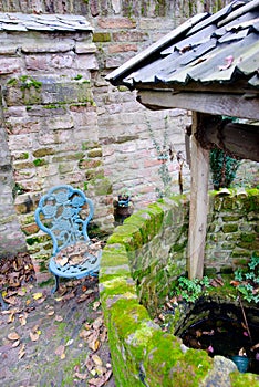 Antique Water Well With a Rope and a Bucket in a idyllic scene