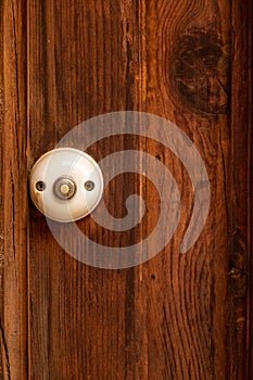 Antique white doorbell on a wooden door