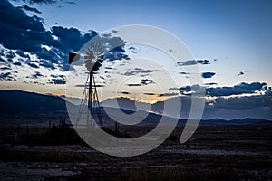 Antique Wind Mill on a Rural Farm With a Colorful Sunset