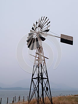 Antique wind mill by the sea