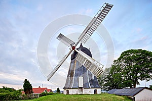 Antique windmill next to house in denmark