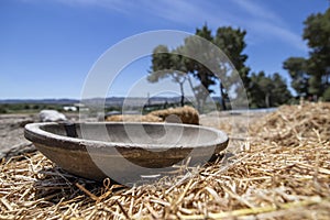 Antique wooden bowl lying on golden straw in the ancient city of Zipori. Israel.