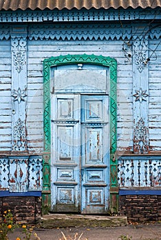 Antique wooden door with carved platbands in blue and green