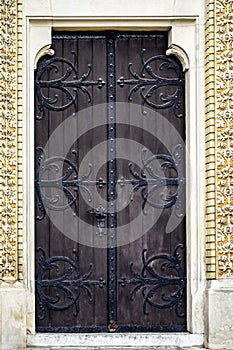 Antique wooden door decorated with wrought iron decorative elements