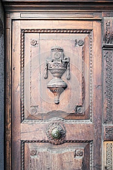 Antique wooden door inlaid with floral motifs and a sort of raised the cup