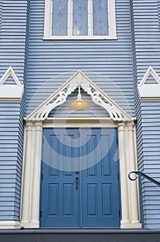 Antique wooden door in to an old wooden church. Blue entrance door. Wooden Gothic Revival style church