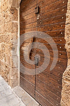 Antique  wooden gate with a wooden handle at the entrance to the residential courtyard in the port in the old city of Acre in
