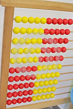Antique wooden red and yellow abacus isolated in classroom