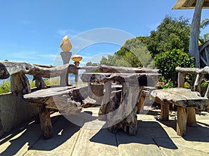 Antique and wooden tables and chairs placed near the beach