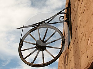 Antique wooden wagon wheel hanging on a wall as a decoration.