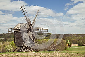 Antique wooden windmill on a hill near the village. Autumn rural landscape