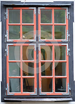 Antique wooden window with a red frame.