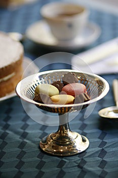 Antiques silver candy pedestal with chocolates and macarons stillife