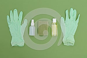 Antiseptic and rubber gloves on green background. Minimal. Undertone photo