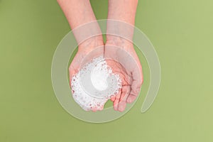 Antiseptic and rubber gloves on green background. Minimal. Undertone photo