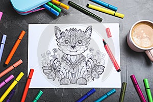 Antistress coloring page, felt tip pens and coffee on black table, flat lay