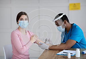 Antiviral protection and immunization. Doctor vaccinating female patient against coronavirus, injecting covid-19 vaccine