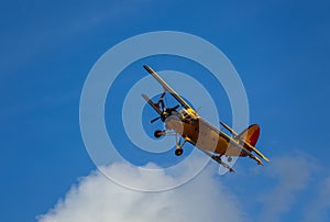 Antonov AN-2 biplane fly on cloudy sky. Old yellow historic plane from side