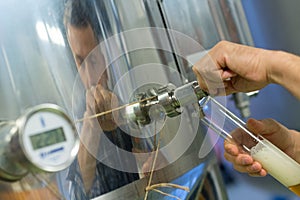 anufacturer working at storage tanks in brewery