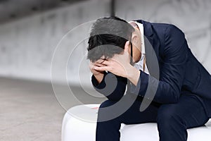 Anxiety stressed young Asian business man suffering from severe trouble