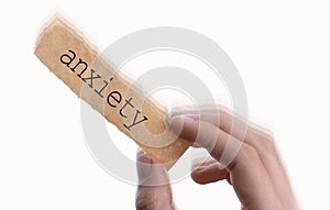 Anxiety wording on blank torn notepaper in hand