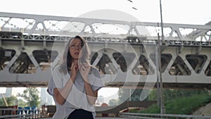 anxious and afraid woman is waiting someone on street in outskirts at summer day