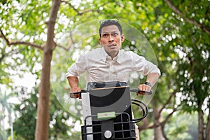 An anxious Asian businessman is in a hurry to get to work in the morning, riding a bike