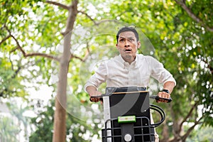 An anxious Asian businessman is in a hurry to get to work in the morning, riding a bike