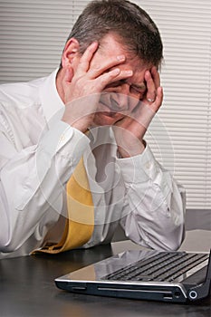 Anxious business man holds head