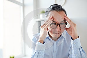 Anxious businessman in eyeglasses at office photo