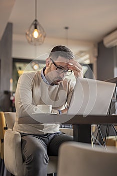 Anxious businessman working on laptop computer