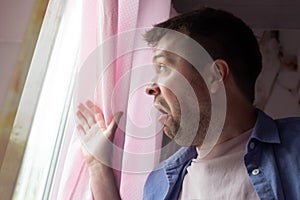 Anxious caucaisian man feel nervous pessimistic look at window wait for someone