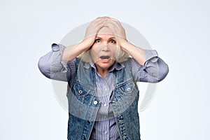 Anxious elderly blonde woman having frustrated stressed expression