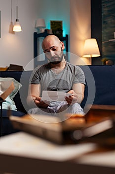 Anxious frustrated depressed young man reading letter