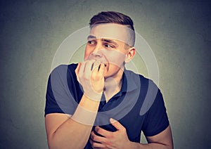 Anxious hesitant man biting his fingernails photo