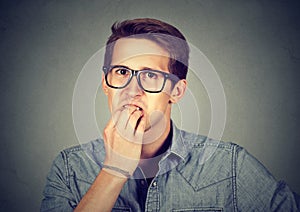 Anxious man biting fingernails nervously