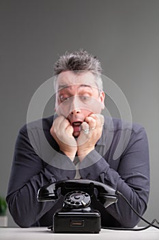 Anxious man looking at a phone in trepidation