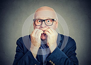 Anxious scared senior man biting fingernails