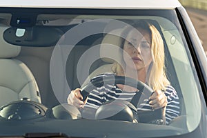 Anxious scared woman driver worried looking at car accident on road through windshield drive vehicle