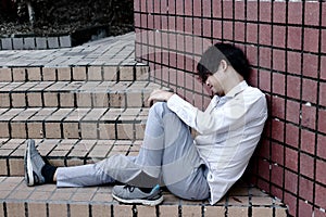 Anxious stressed Asian business man in depression sitting on the floor