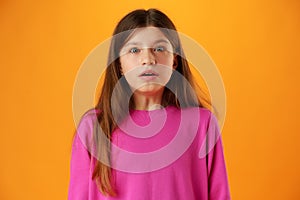 Anxious teen girl looking scared or worried on yellow background