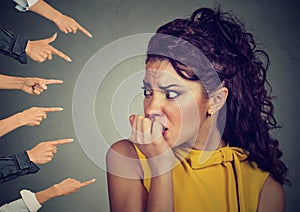 Anxious woman judged by different people fingers pointed at her