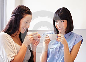 Anything can be fixed by a moment with good friend. Two women sharing an enjoyable moment in the kitchen over coffee.