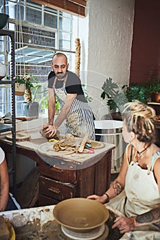 Anything handmade is totally worth the mess. a young man and woman working with clay in a pottery studio.