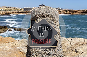 Anything is possible symbol. Concept words Anything is possible on beautiful black chalk blackboard. Beautiful red stone blue sea