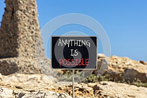 Anything is possible symbol. Concept words Anything is possible on beautiful black chalk blackboard. Beautiful red stone blue sky