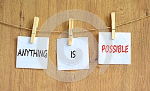 Anything is possible symbol. Concept words Anything is possible on beautiful white paper on clothespin. Beautiful wooden table